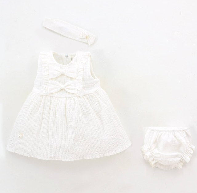 White baby dress and diaper on a white background with Leoking branding.